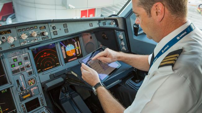 Next step. Qantas pilot using an iPad in the cockpit - soon the devices will operate at 35,000-feet. Picture: Brett Winstone