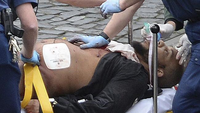 Attacker Khalid Masood is treated by emergency services outside the Houses of Parliament. Picture: Stefan Rousseau/PA via AP