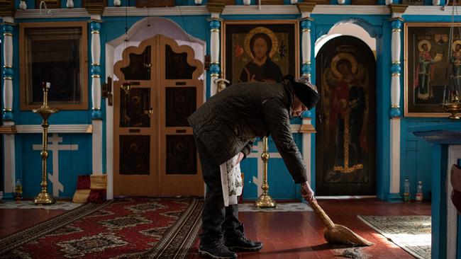 Relatives clean the church before a funeral in Bila Krynytsia village, Chernivtsi region, Ukraine.