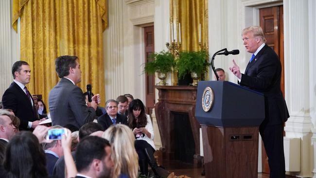 TOPSHOT - US President Donald Trump (R) gets into a heated exchange with CNN chief White House correspondent Jim Acosta (C) as NBC correspondent Peter Alexander (L) looks on during a post-election press conference in the East Room of the White House in Washington, DC on November 7, 2018. (Photo by MANDEL NGAN / AFP)