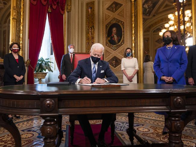 The president signs three documents including an Inauguration declaration, cabinet nominations and sub-cabinet nominations, as US Vice President Kamala Harris watches on in the Presidents Room at the US Capitol. Picture: Getty Images