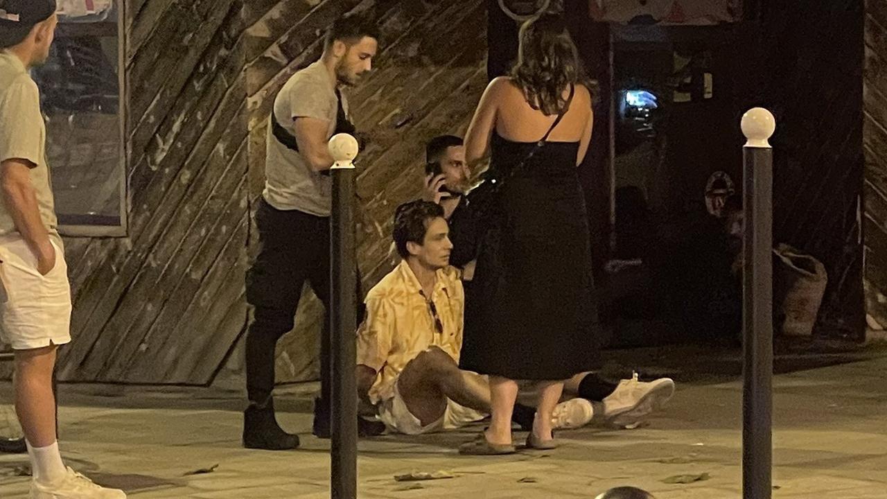 Australian hockey player Tom Craig sits on the footpath in Paris after being arrested for buying cocaine.