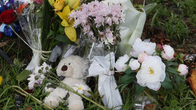 Floral tributes at the scene of the crash lay among broken car pieces and tree bark where a 14 year old boy died. Five other children aged 12 to 15 were taken to Cairns Hospital with injuries and the driver, 14, has now been charged with manslaughter. Picture: Brendan Radke