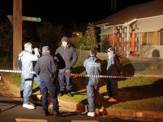 Police and forensic experts near the family murder site.