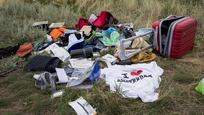 Luggage and personal belongings from passengers on board MH17 in a field. Picture: Getty