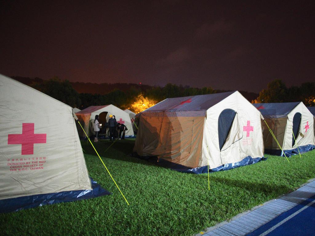 Earthquake affected people stand outside tent a at a temporary reception centre at a local school in Hualien. Picture: AFP