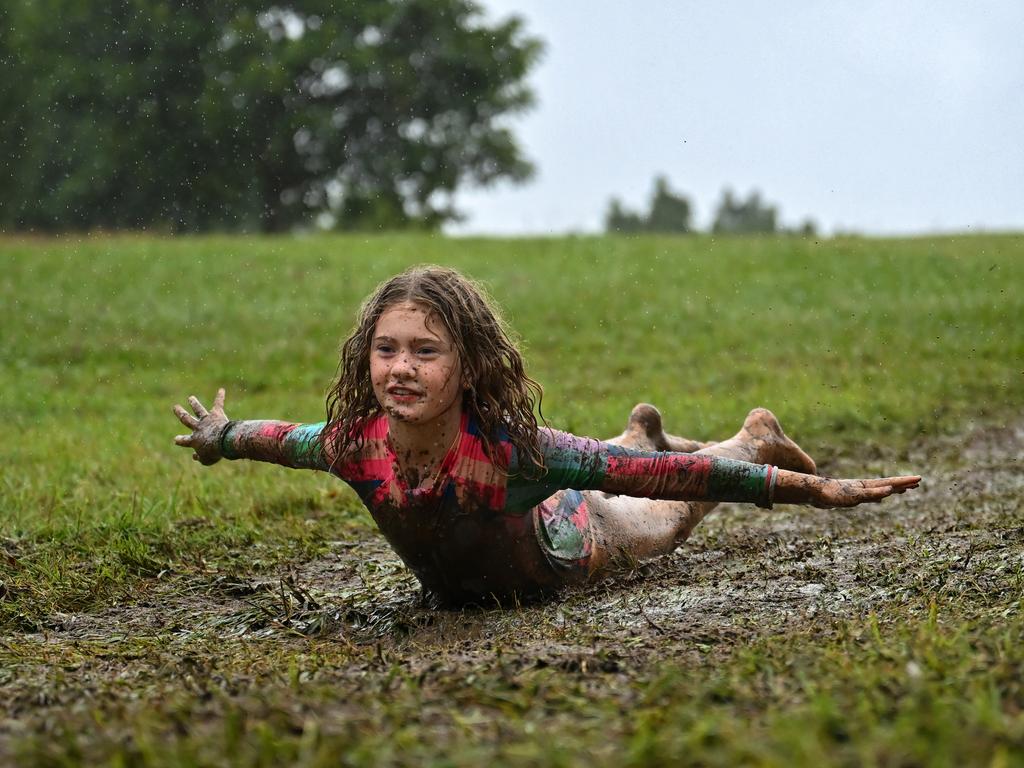 Children slide down a mud hill in the suburb of Upper Kedron on March 8. Picture: Albert Perez/Getty Images