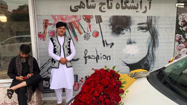 Men stand outside a beauty salon in Kabul last week after all beauty parlours were ordered to shut. Picture: AFP