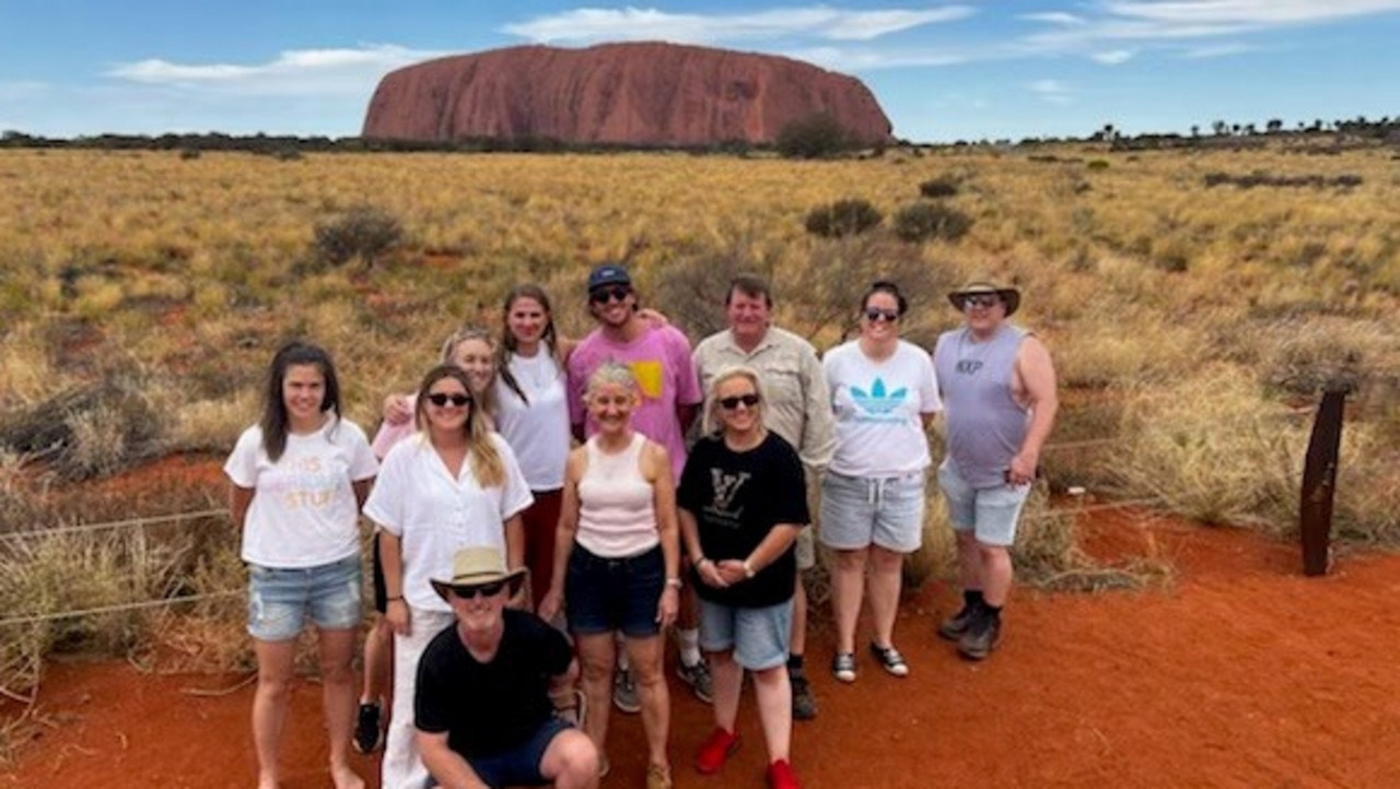 Kym Powell, left, Louisa Davis, Erin Welgus, Sophia Clements, Heidi Turton, Kelli Gray, Brooke Gregory, David Gahan, Natasha Craig and Stuart McLeod with Mal Ellwood, front, on the The Northern Territory Learning Adventures familiarisation tour at Uluru.