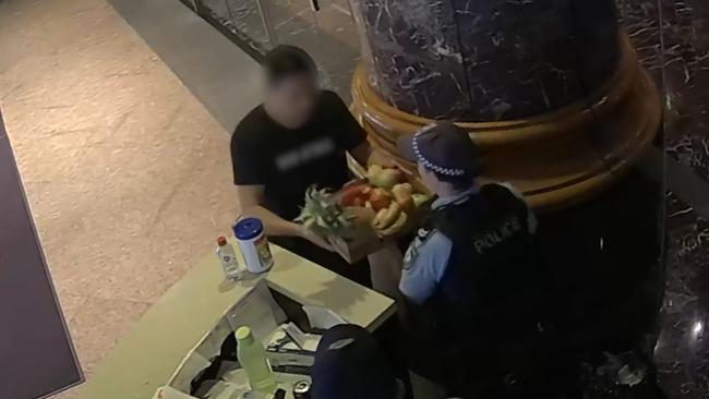 Before handing a box of fruit over to police guarding the hotel.