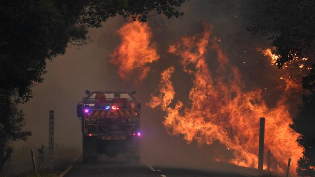 The fearless Bonville crew drive through the flames of a fierce bushfire in Nana Glen, near Coffs Harbour, on Tuesday, November. Picture: AAP/Dan Peled