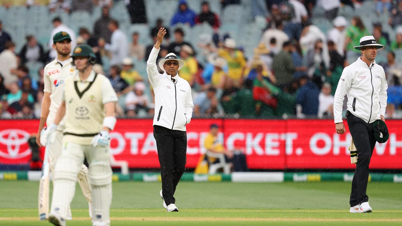 Umpire Joel Wilson signals for covers to be brought on to the MCG pitch midway through the second session after heavy rain hit the MCG. Picture: Robert Cianflone / Getty Images