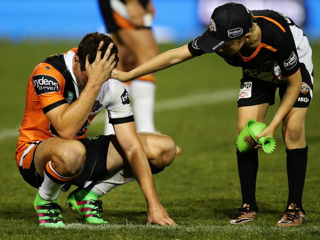 A ball boy consoles Tigers Mitchell Moses after the Tigers loss in golden point extra time in the Wests Tigers v Melbourne Storm rugby league game at Leichhardt Oval, Sydney. Pic Brett Costello