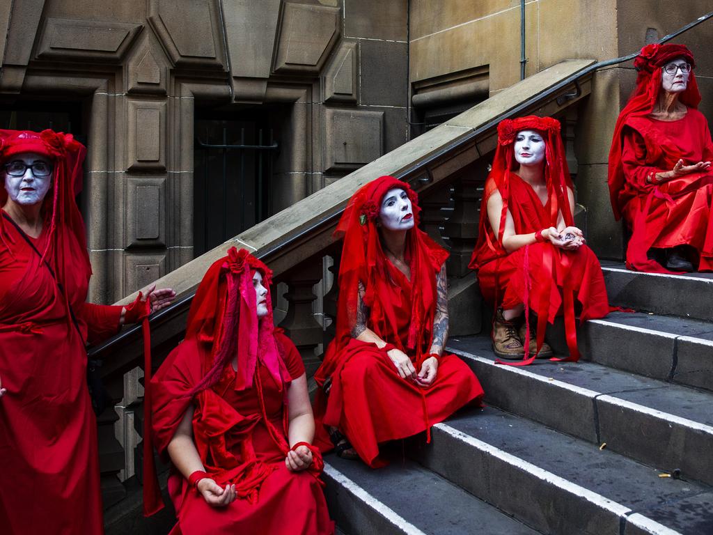 SYDNEY, AUSTRALIA - JANUARY 10: Members of the red brigade look on as activists rally for climate action at Sydney Town Hall on January 10, 2020 in Sydney, Australia. Protests around the country were organised in response to the ongoing bushfire crisis in Australia. Fires in New South Wales, Victoria, Queensland, Western Australia and South Australia have burned 8.4 million hectares of land. At least 25 people have been killed, including three volunteer firefighters, and thousands of homes and buildings have been destroyed. (Photo by Jenny Evans/Getty Images)