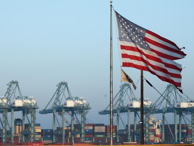 SAN PEDRO, CALIFORNIA - NOVEMBER 07: An American flag flies nearby with shipping containers stacked at the Port of Los Angeles in the background, which is the nation's busiest container port, on November 7, 2019 in San Pedro, California. Port officials said today October cargo volume was down 19 percent this year compared with October 2018 due to tariffs imposed in the U.S.-China trade war. The Port of Los Angeles along with neighboring Port of Long Beach are the United States' main gateways for trade with Asia. (Photo by Mario Tama/Getty Images)