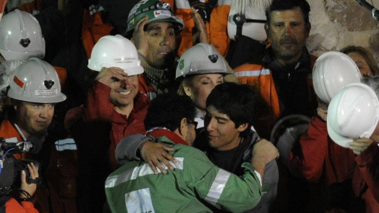 The last of the 33 Chilean miners to be rescued, Luis Urzua, embraces a family member after being brought to the surface on this day in 2010.