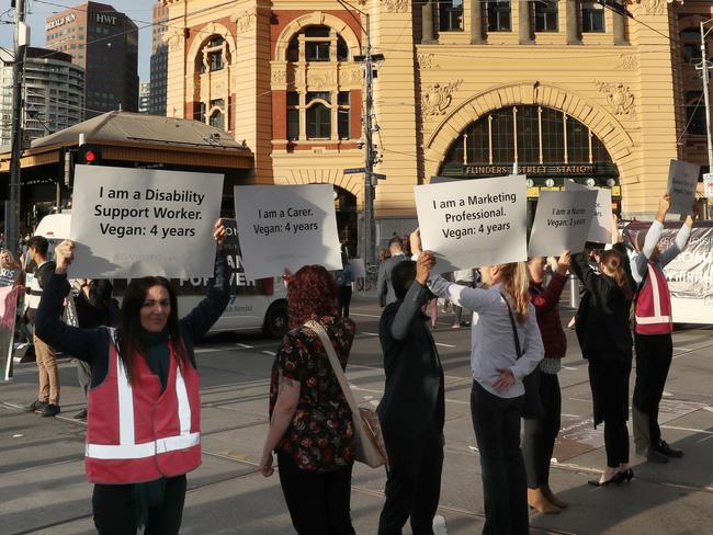 Animal rights protesters block the intersections of Flinders and Swanston Street during early morning traffic in Melbourne, Monday, April 8, 2019. Animal rights protesters are blocking a CBD intersection while south east of Melbourne, others have chained themselves to a truck. (AAP Image/David Crosling) NO ARCHIVING