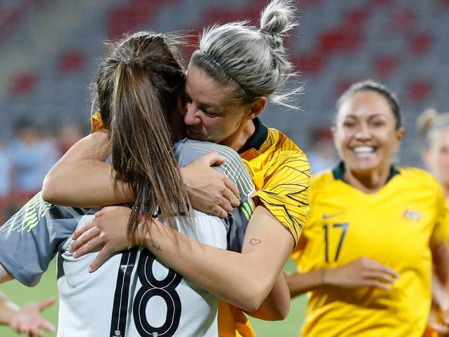 Australia's defender Alanna Kennedy (C) hugs teammate goalkeeper Mackenzie Arnold after defeating Thailand on penalties during the AFC Women's Asian Cup Semi Final match between Australia and Thailand at the King Abdullah II Stadium in the Jordan city of Amman on April 17, 2018. Australia defeated Thailand 3-1 in penalties after a 2-2 draw after full time. / AFP PHOTO / JACK GUEZ