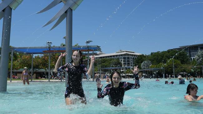 Grace and Summer Patterson escaping the heat under the sprinklers. Picture: Nuno Avendano