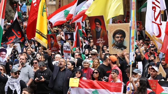 People hold up pictures of Hezbollah leader Hassan Nasrallah and the Hezbollah flag at a protest at Town Hall in Sydney last weekend. Picture: NewsWire / Damian Shaw