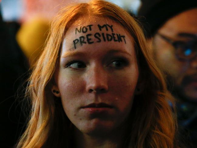 A woman looks on as she takes part in a protest against President-elect Donald Trump in front of Trump Tower in New York on November 10, 2016. / AFP PHOTO / KENA BETANCUR