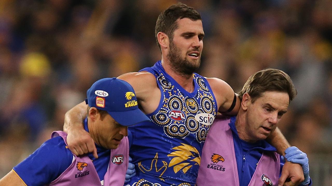 Jack Darling of the Eagles is assisted from the field with a lower leg injury.