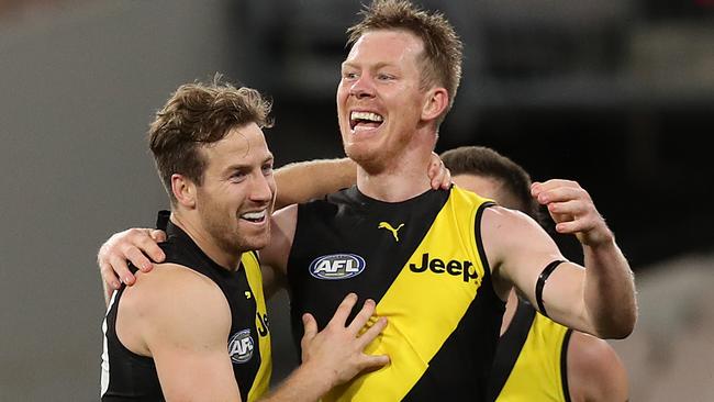 MELBOURNE, AUSTRALIA - JULY 05: Kane Lambert of the Tigers (L) celebrates with teammates Jack Riewoldt of the Tigers after kicking a goal during the round 5 AFL match between the Melbourne Demons and the Richmond Tigers at Melbourne Cricket Ground on July 05, 2020 in Melbourne, Australia. (Photo by Graham Denholm/AFL Photos via Getty Images)