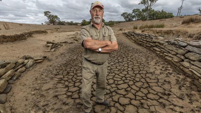 Farmer Peter Williams standing in an empty dam, on his property in Mount Torrens. Picture: Ben Clark