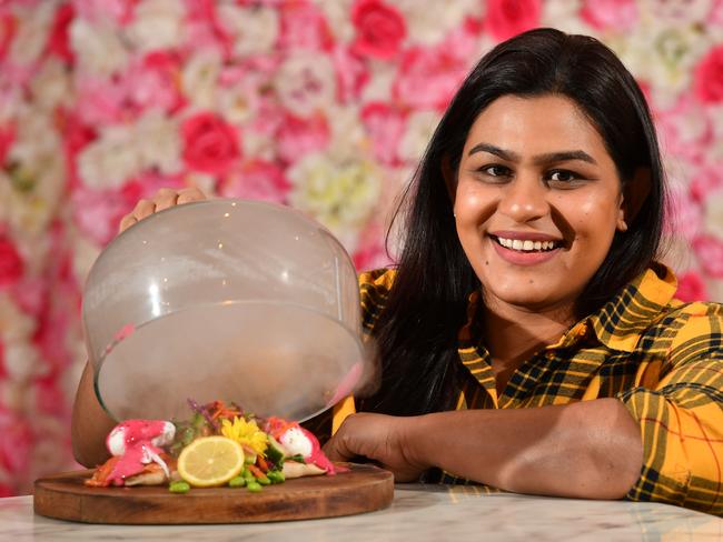 Sithara Rajakaruna poses for a photograph in her business Coconut Estate Eatery in North Adelaide on Friday the 19th of July 2019. Sithara with Eggs Benedict with a cloche of smoke. Coconut Estate Eatery is a finalist in the city awards best dining experience category. (AAP/ Keryn Stevens)