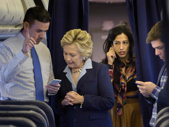 Democratic presidential nominee Hillary Clinton (second left) with national press secretary Brian Fallon (left), aide Huma Abedin (second right) and travelling press secretary Nick Merrill (right) on her plane. Picture: AFP/Brendan Smialowski