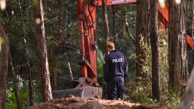 A NSW Police Detective watches as a digger searches bushland in the Royal National Park south of Sydney, Wednesday, May 31, 2017. Picture: AAP Image/Dean Lewins.