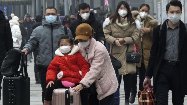 Travellers wear masks at Yichang train station, west of Wuhan, on Wednesday. Picture: AP