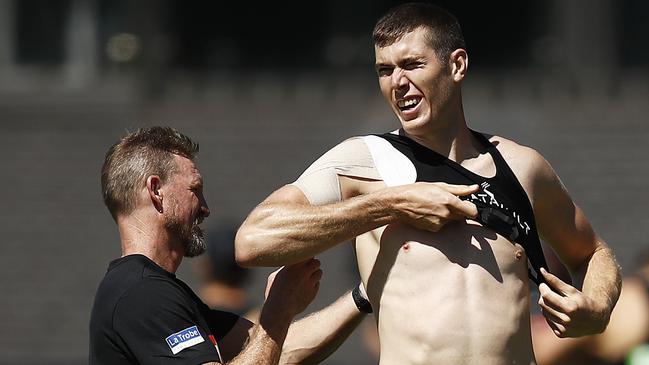 Nathan Buckley helps Mason Cox with his GPS tracker. Picture: Getty Images