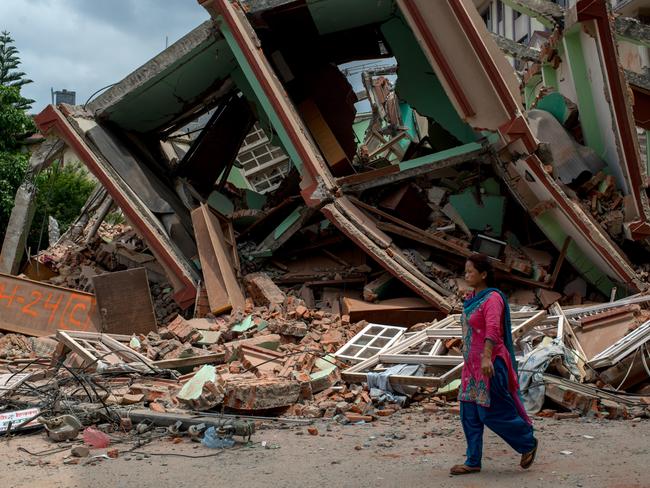 KATHMANDU, NEPAL - MAY 13: People walk past the rubble of destroyed buildings following a second major earthquake May 13, 2015 in Kathmandu, Nepal. A 7.3 magnitude earthquake struck in Nepal only two weeks after more than 8,000 people were killed in a devastating earthquake. The latest quake struck near Mt Everest near the town of Namche Bazar. Tremors were felt as far away as Bangladesh and Delhi. (Photo by Jonas Gratzer/Getty Images)