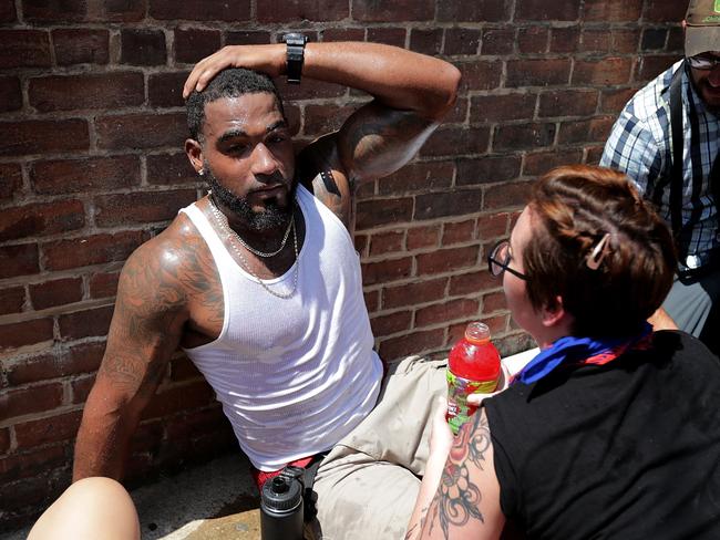 Rescue workers and volunteer medics tend to people who were injured when a car ploughed through a crowd of anti-fascist counter-demonstrators. Picture: AFP