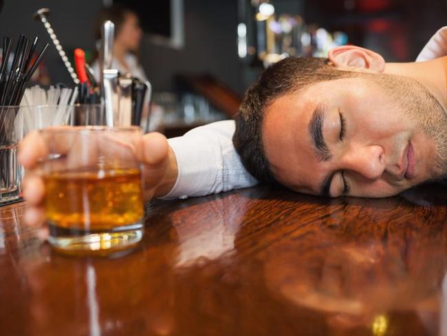 Drunk and unconscious businessman lying on a counter