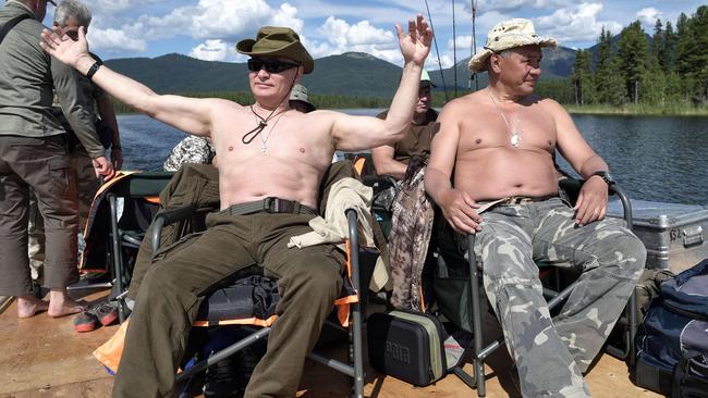 Russian President Vladimir Putin, left, accompanied by defence minister Sergei Shoigu, gestures as he fishes in the remote Tuva region in southern Siberia in August, 2017. Picture: AFP