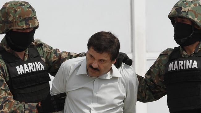 Guzman is escorted to a helicopter in handcuffs by Mexican navy marines after his arrest in February 2014. Picture: AP / Marco Ugarte