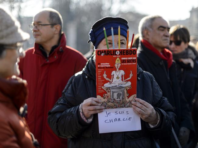 A woman holds a copy of Charlie Hebdo during a gathering in the center of Geneva on January 8. Picture: Fabrice Coffrini.