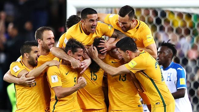 The Socceroos celebrate scoring a goal.