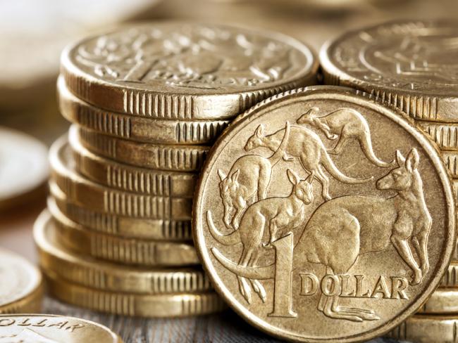 Stacks of Australian one dollar coins. Focus on front coin.