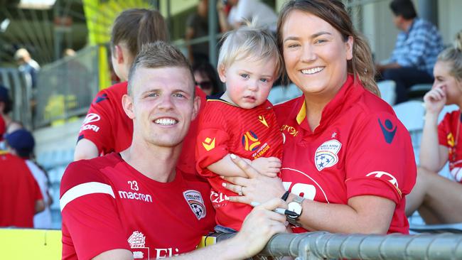 Adelaide United defender Jordan Elsey with Reds supporter Micayla Cleland and her daughter Amelia, 17 months. Picture: Tait Schmaal