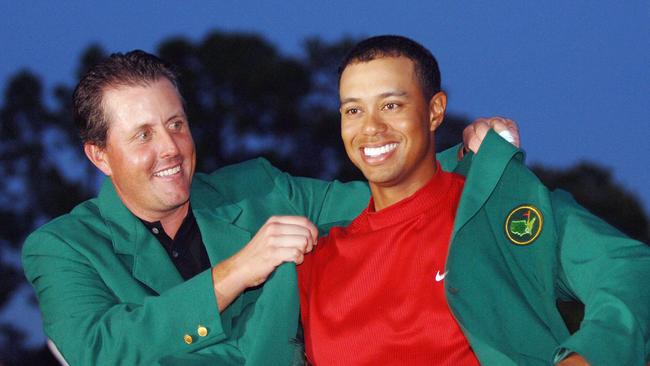 2004 champion Phil Mickelson (L) presents 2005 champion Tiger Woods with his green jacket after winning US Masters tournament on first play-off hole against DiMarco at Augusta National Club in Augusta, Georgia.