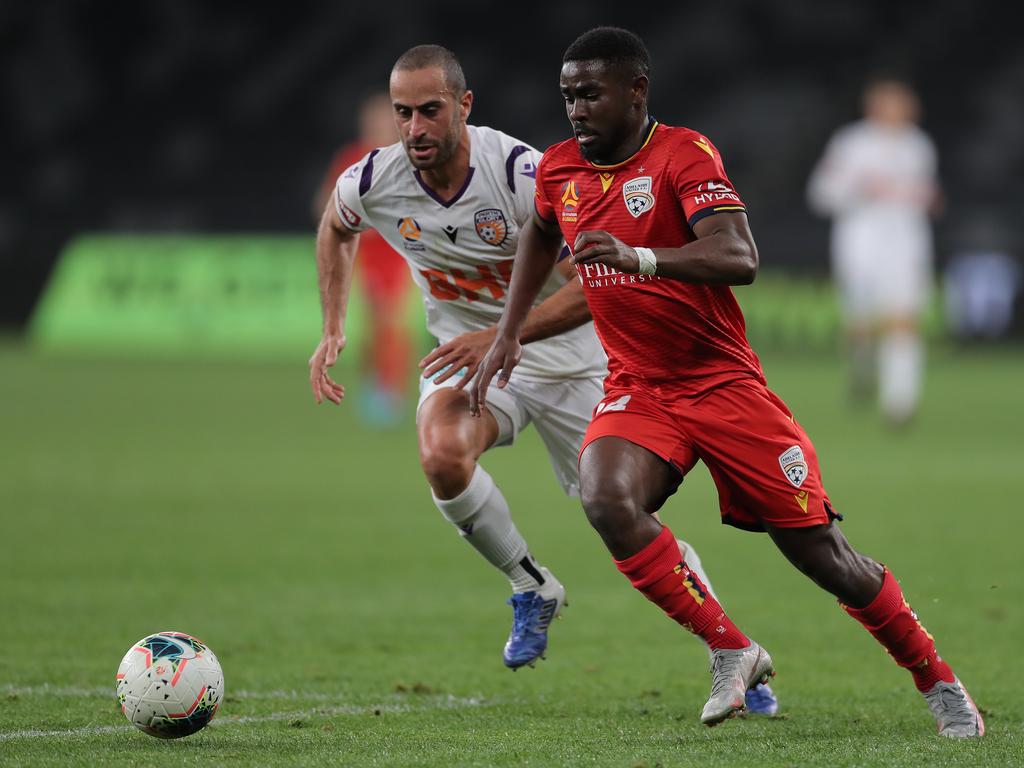 Adelaide United goalscorer Pacifique Niyongabire is chased by Perth Glory’s Tarek Elrich in the Reds’ 5-3 win. Picture: Matt King/Getty Images