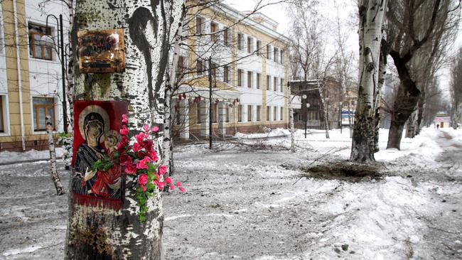Deadly attacks ... flowers are hung on a tree near a crater due to shellings between Ukrainian army and pro-Russian separatists in Donetsk. Picture: AFP