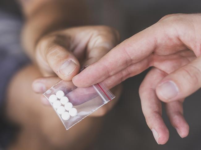 Drug dealer selling ecstasy pills to a drug addict