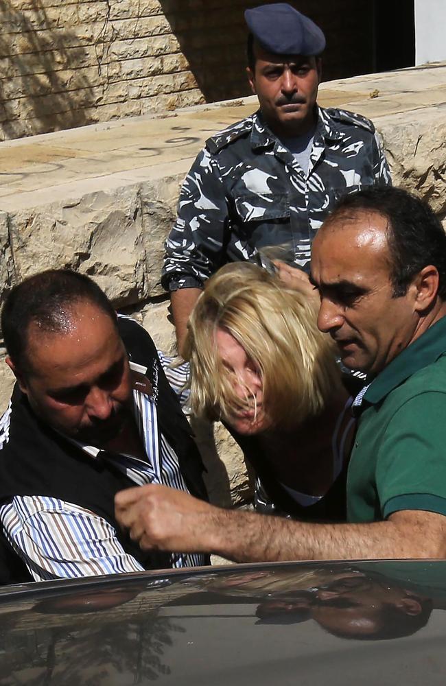 Lebanese policemen surround Australian TV presenter Tara Brown while escorting her from the courthouse. Picture: AFP / MARWAN TAHTAH