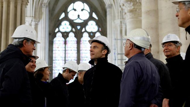 French President Emmanuel Macron (centre), talks with conservation experts during the restoration of Notre-Dame. Picture: AFP