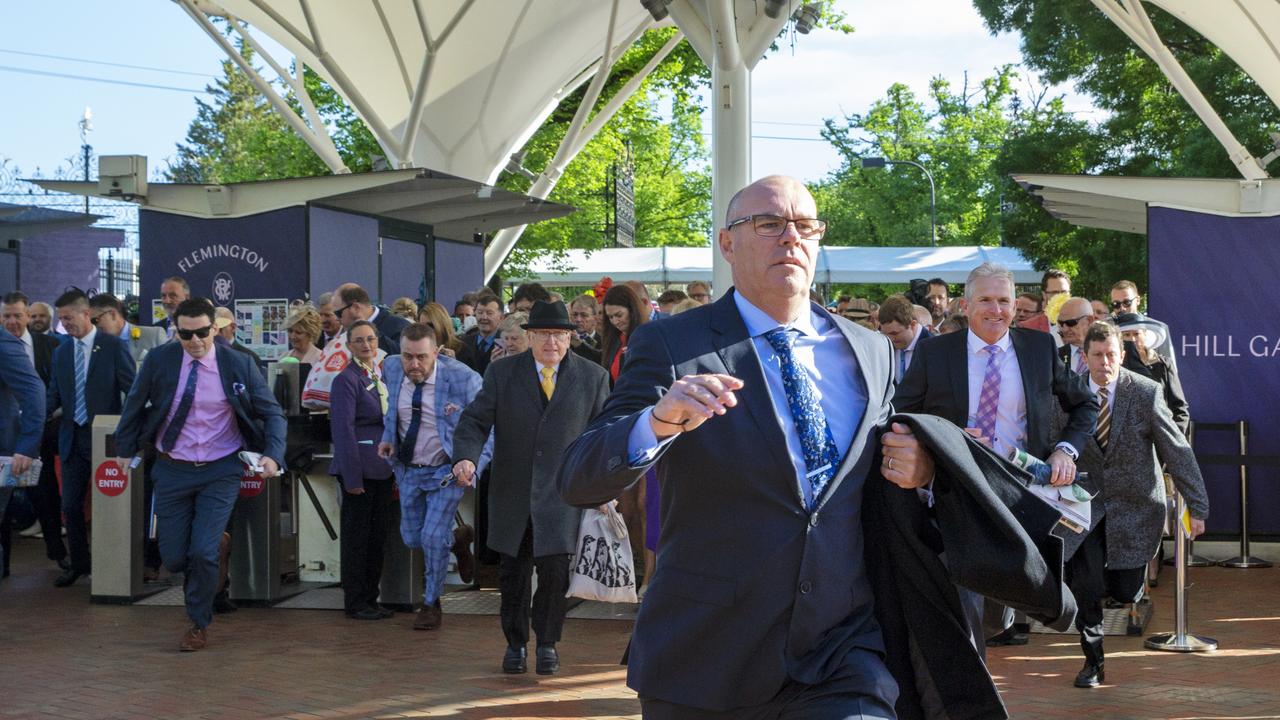 Racegoers run as the turnstiles officially open. Picture: Getty Images