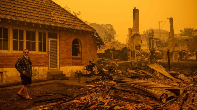 Gary Hinton stands among rubble after fires devastated the New South Wales town of Cobargo. Picture: AFP